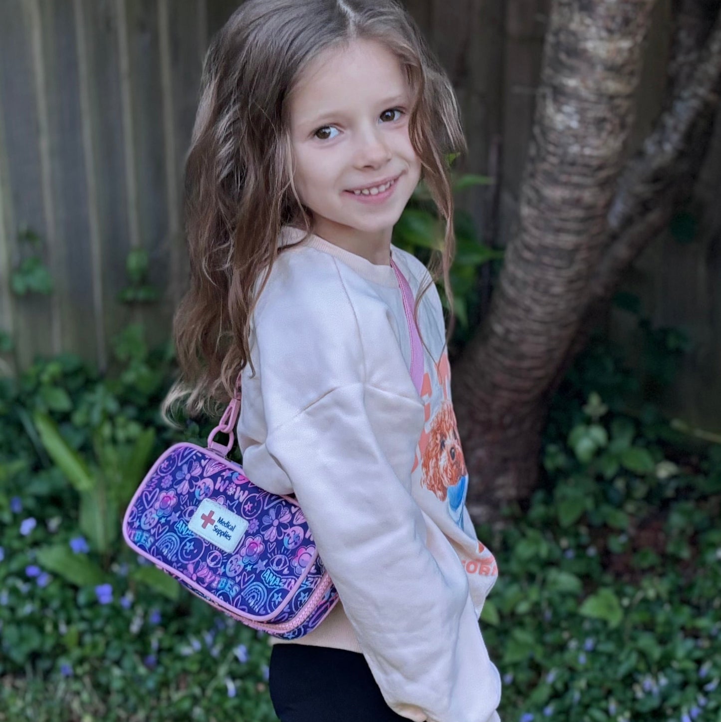 Young girl carrying a purple Epicase in a garden setting