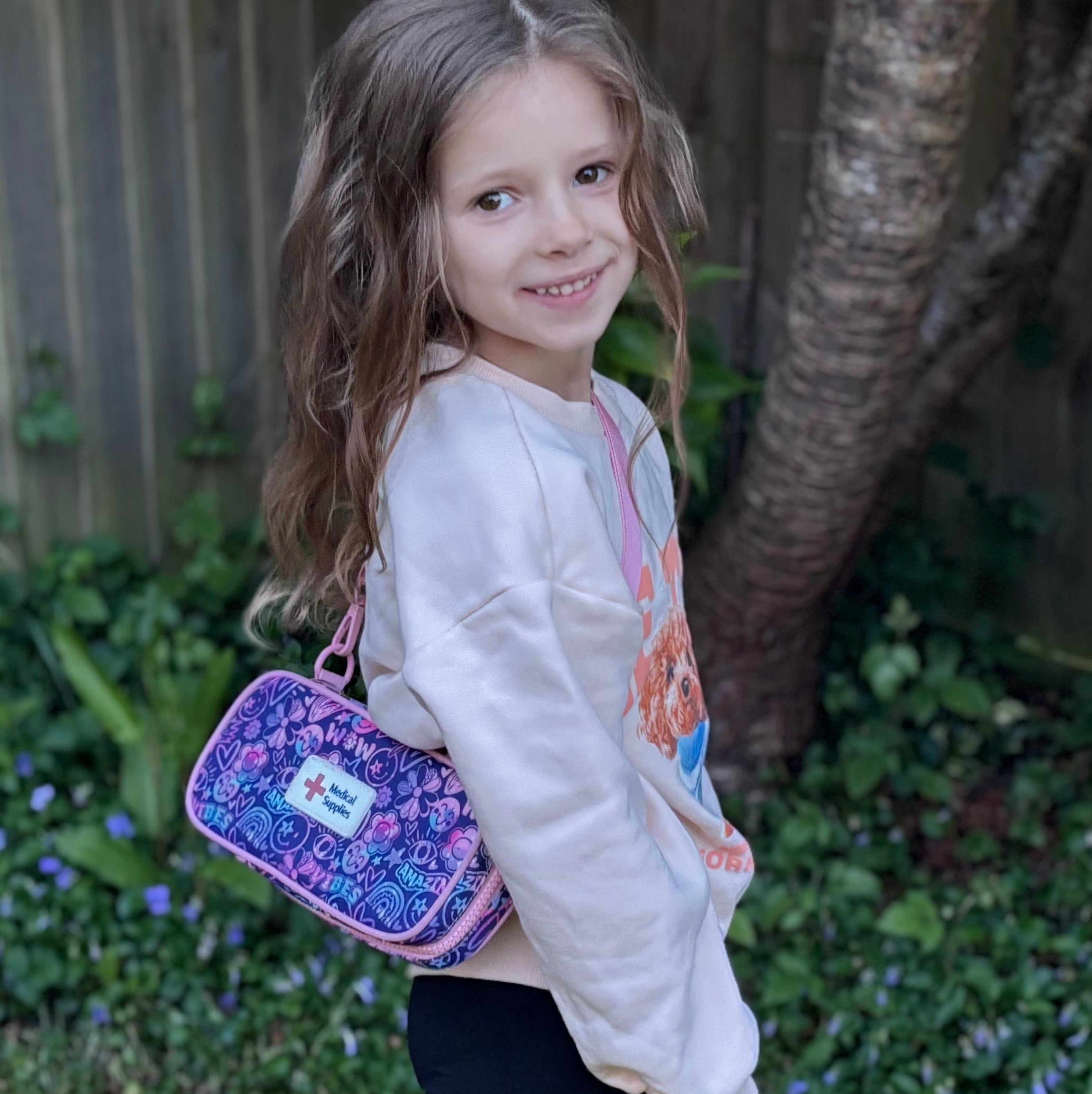 Young girl carrying a purple Epicase in a garden setting
